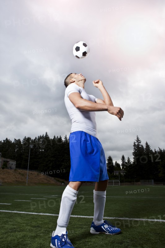 Hispanic athlete heading soccer ball