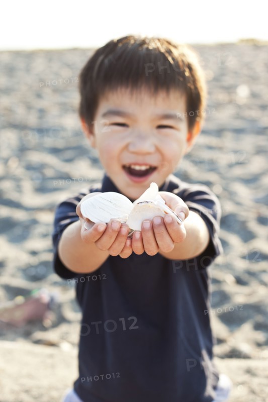 Chinese boy holding out handful of shells