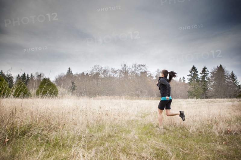 Asian woman jogging in field