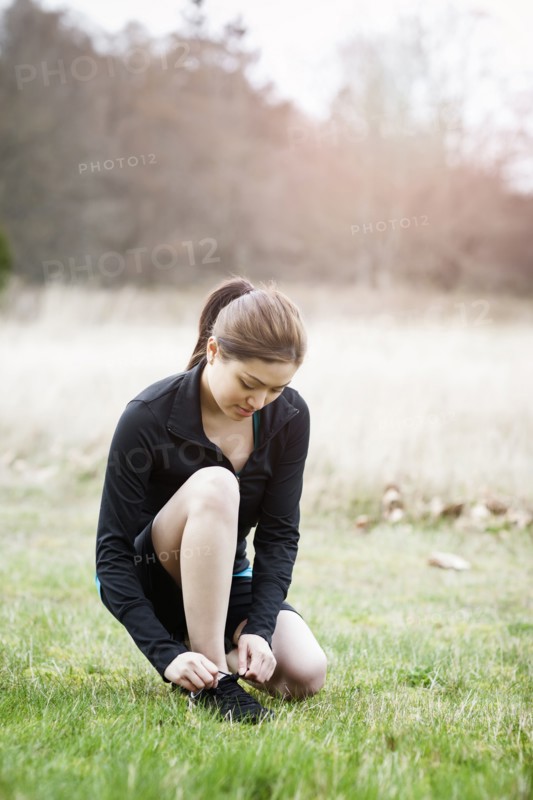 Asian woman tying her shoes