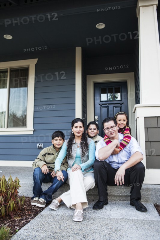 Family smiling on front stoop