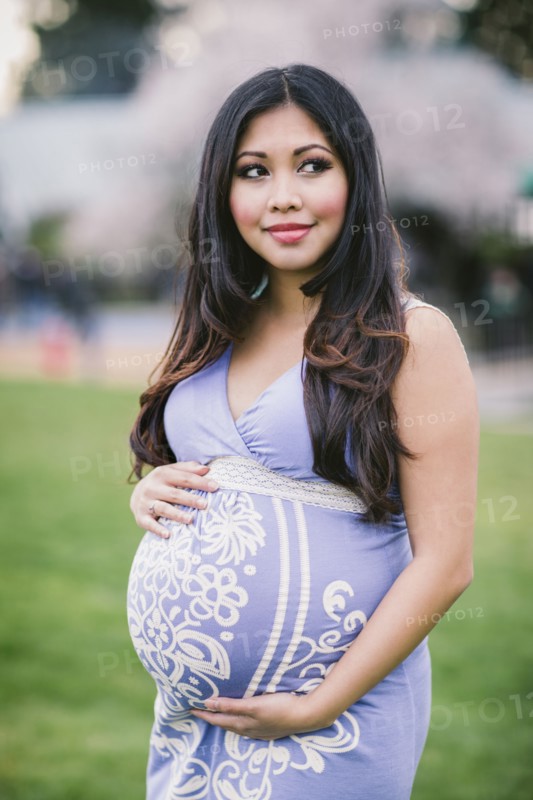 Asian woman holding her pregnant belly