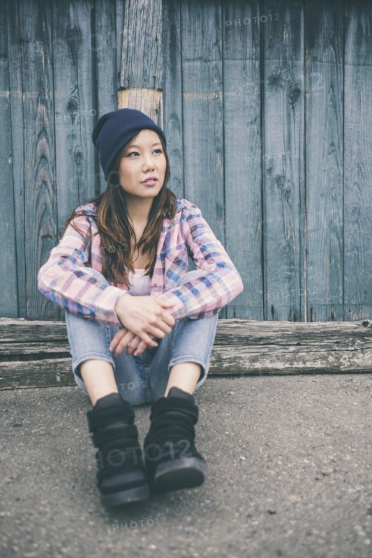 Korean woman sitting on city street