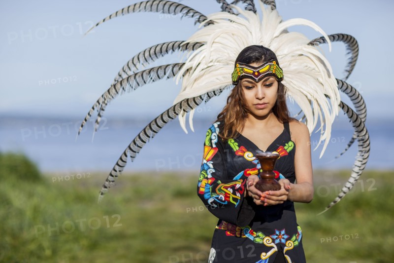 Native American woman in traditional headdress performing ceremony