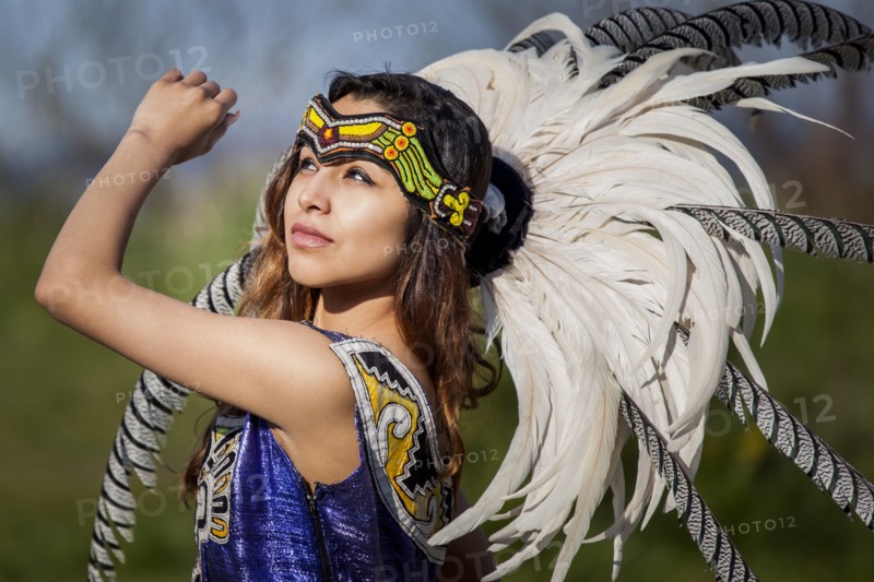 Native American woman in traditional headdress performing ceremony