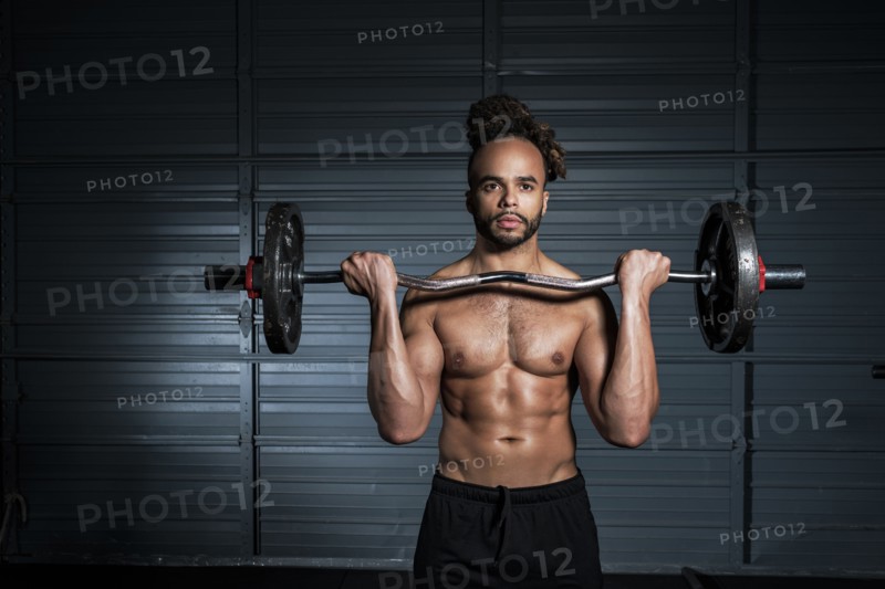 Mixed Race man lifting weights in gymnasium