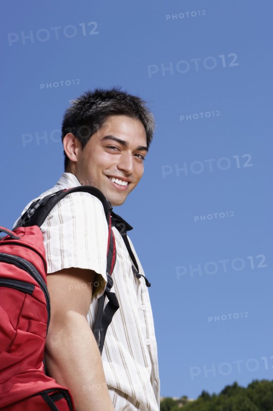 Hispanic man wearing backpack outdoors