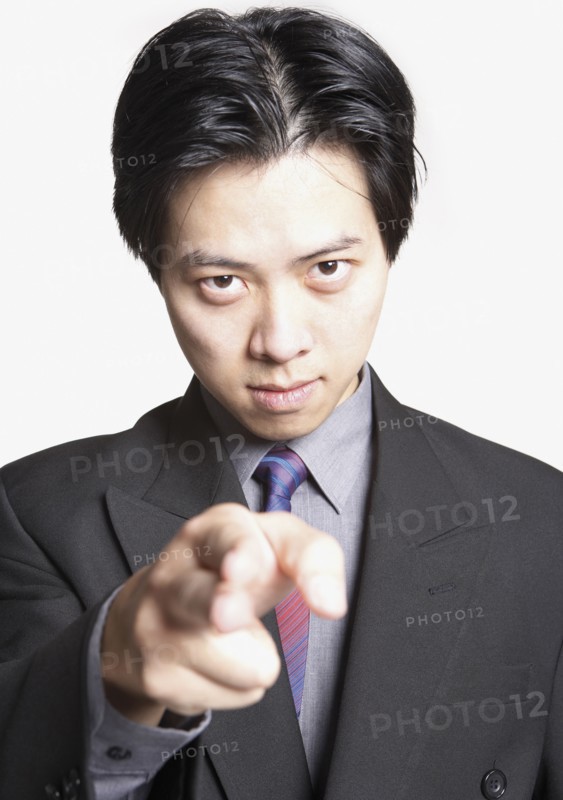 Studio shot of Asian businessman pointing finger