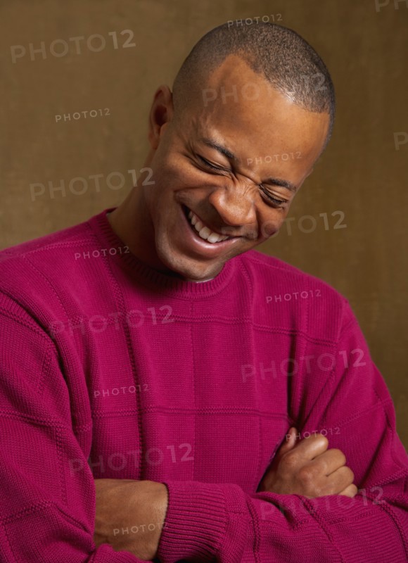 African man laughing with arms crossed