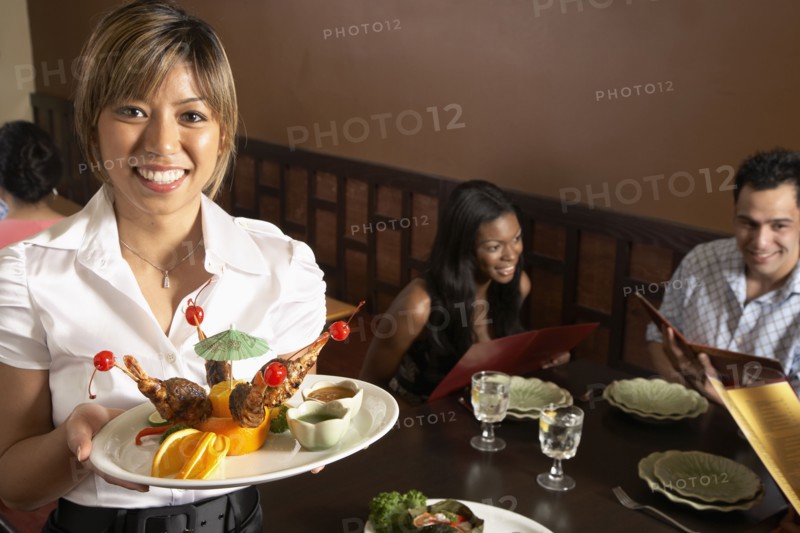 Asian female server holding plate of food