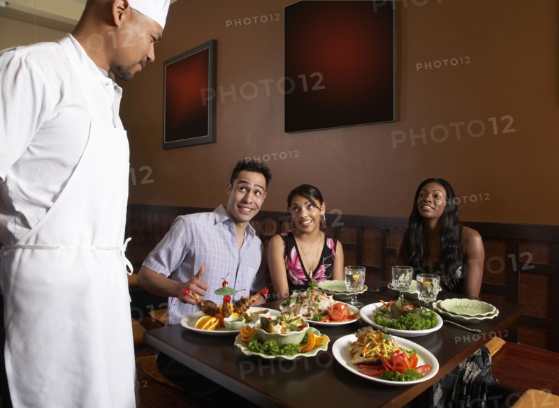 Multi-ethnic friends complimenting chef