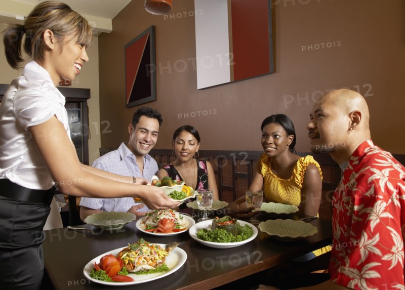 Asian female server bringing food to table