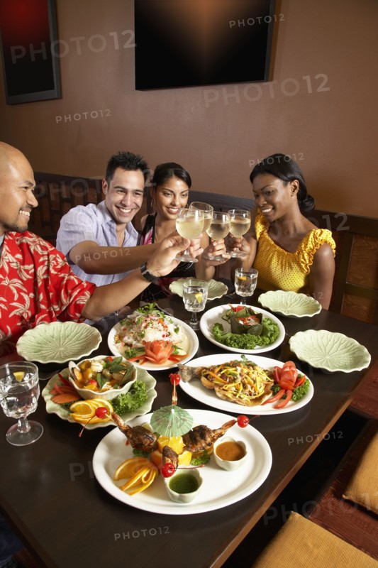 Multi-ethnic friends toasting at restaurant
