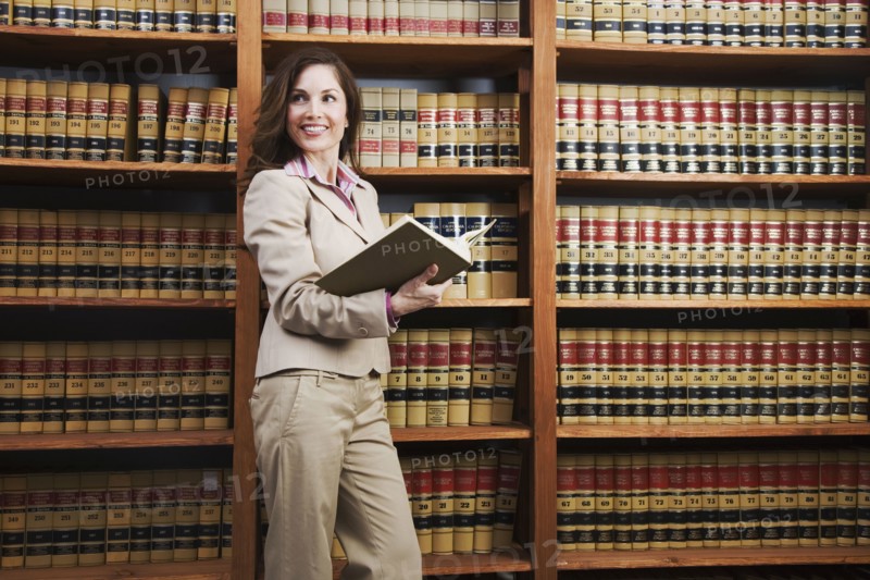 Hispanic woman reading library reference book