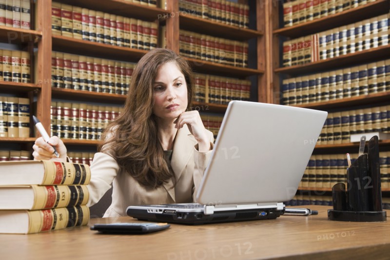 Hispanic woman looking at laptop