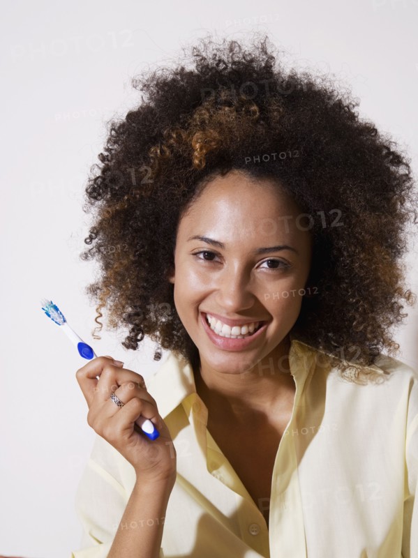 African woman holding toothbrush