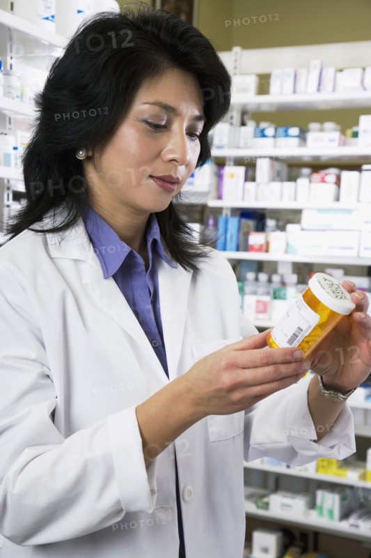 Asian pharmacist reading medication