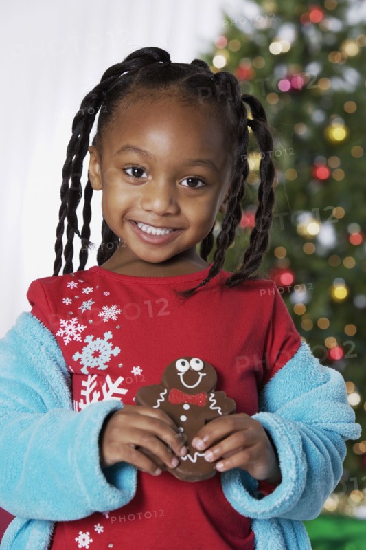 African girl holding Christmas cookie