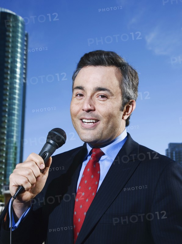 Hispanic male reporter holding microphone