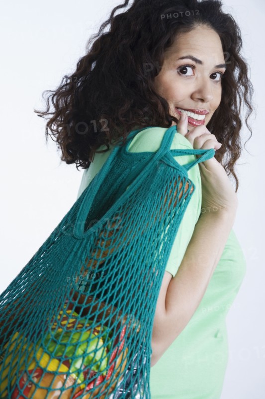 Mixed race woman holding reusable grocery bag