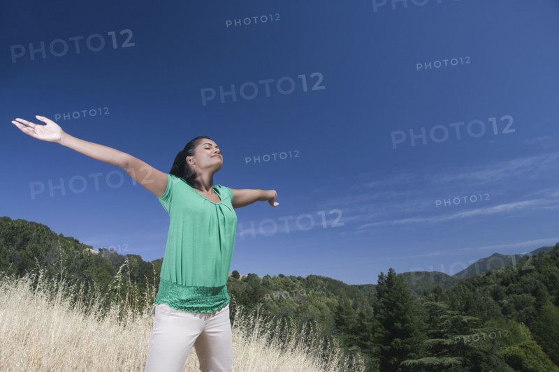 Mixed race woman outdoors with arms outstretched