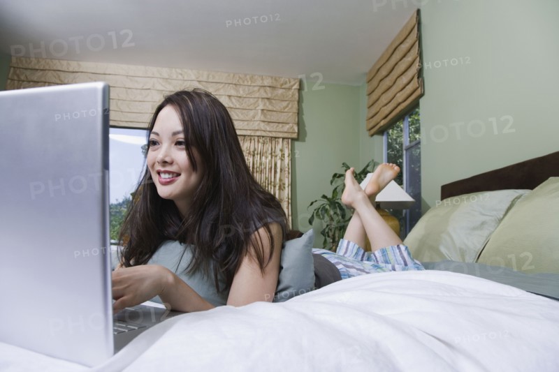 Woman using laptop in bed
