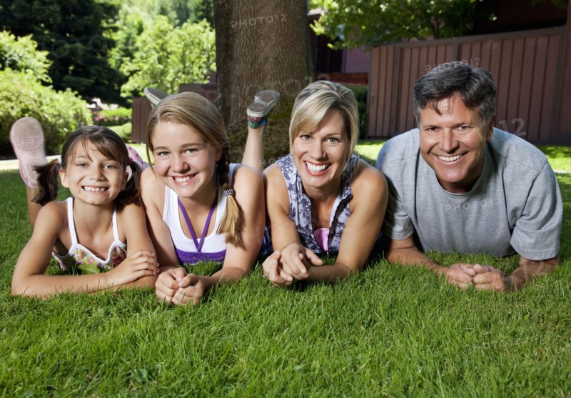 Caucasian family laying in grass