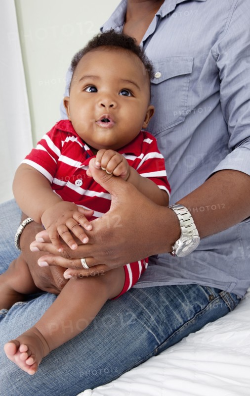 African American father holding baby son on lap