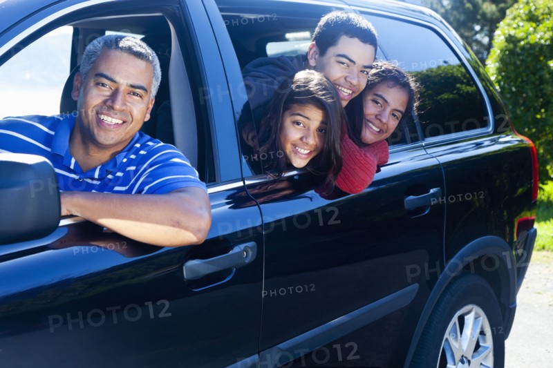 Hispanic family smiling in car