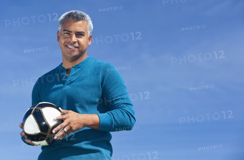 Mixed race man playing soccer outdoors