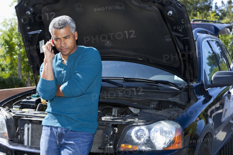 Mixed race man with broken down car