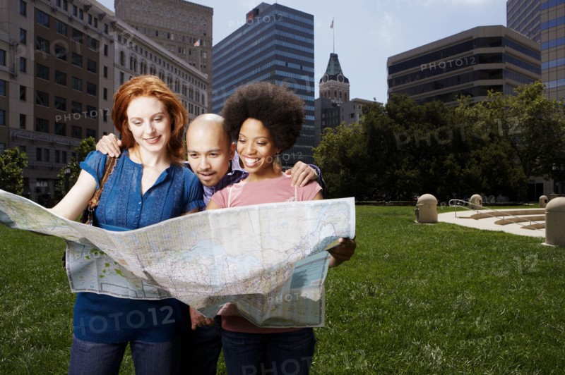 Friends reading map in urban park