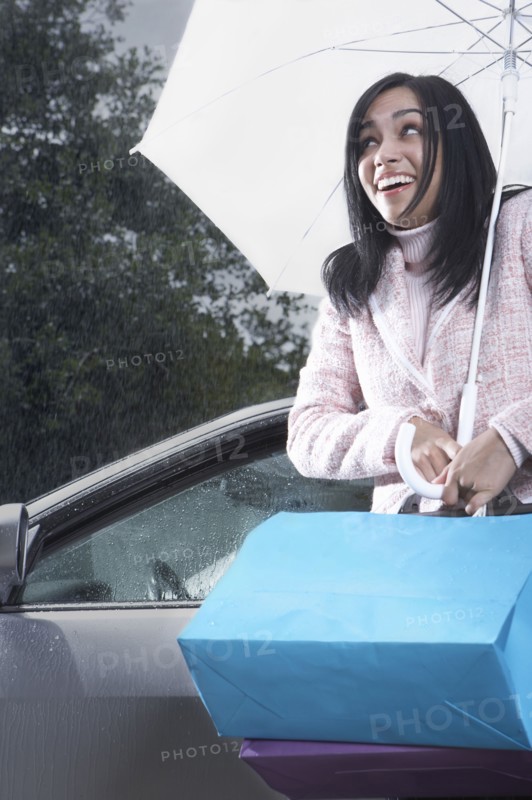 Indian woman carrying umbrella in rain