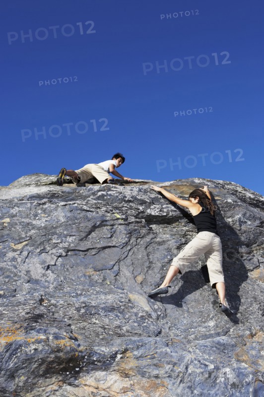 Climbers scaling steep rock face