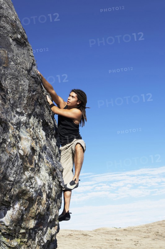 Hispanic climber scaling steep rock face