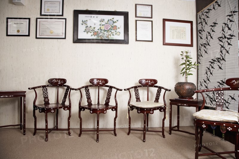 Ornate wooden chairs and picture frames in living room