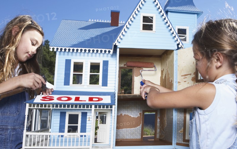 Mixed race girls fixing up doll house for sale
