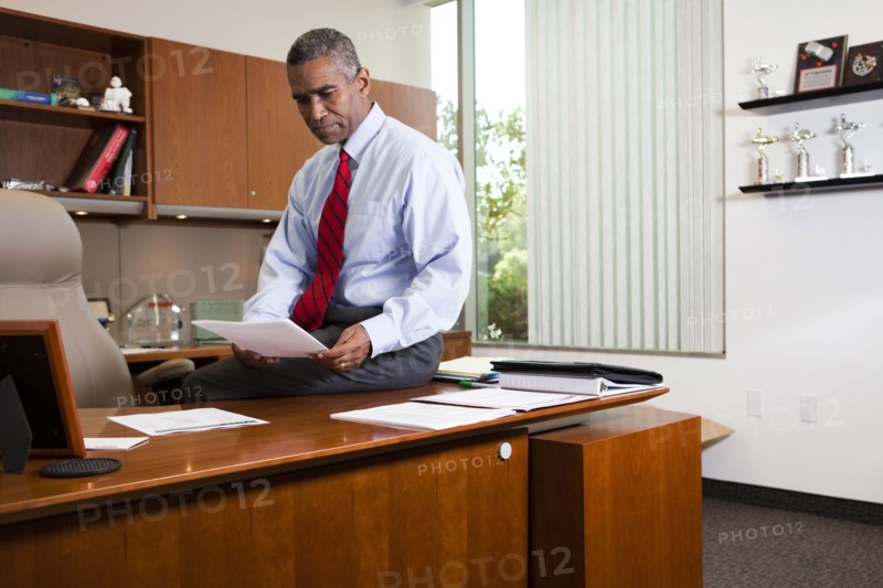 African American businessman sitting on desk