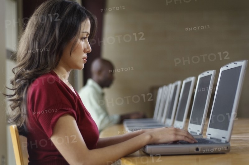 Hispanic woman using laptop at computer lab