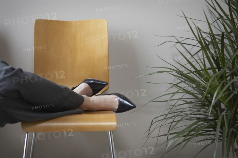 Close up of businesswoman's feet on chair
