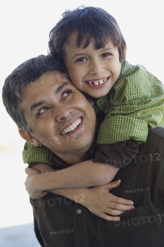 Hispanic boy hugging father