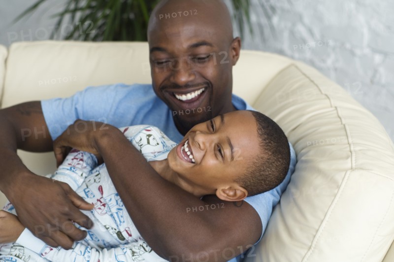 African father tickling son