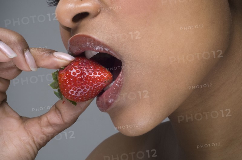 African woman eating strawberry