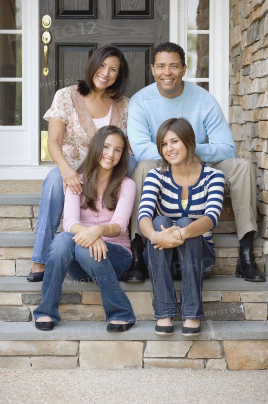 Hispanic family sitting on porch steps