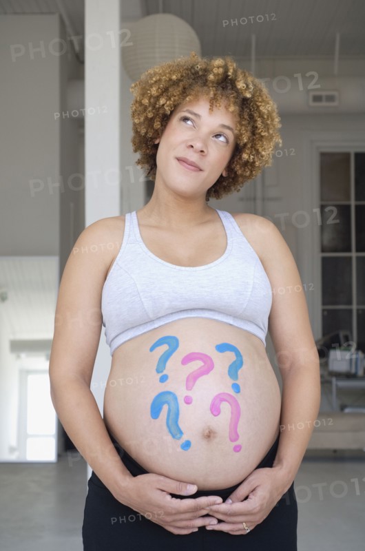 Pregnant African woman with question marks painted on belly