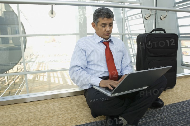 Hispanic businessman typing on laptop