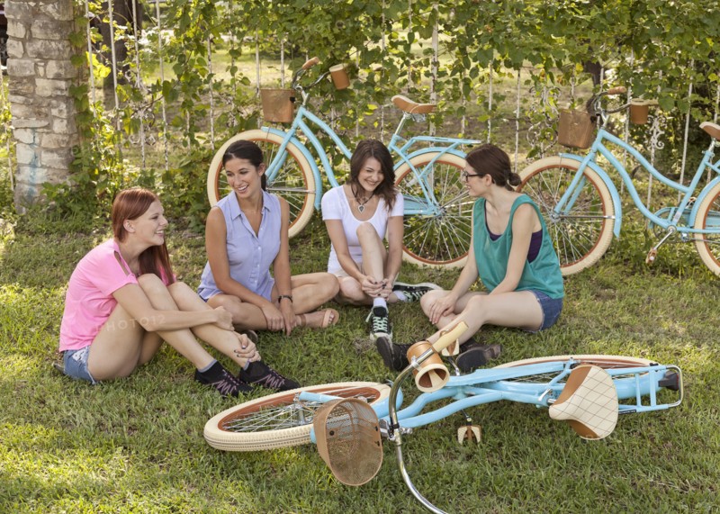 Women sitting with bicycles in grass