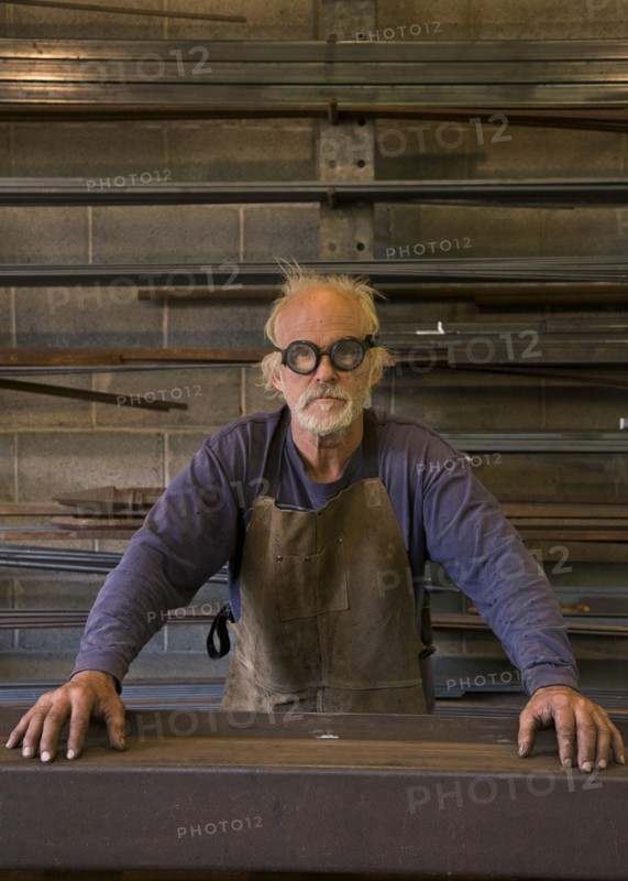 Portrait of serious Caucasian blacksmith in workshop