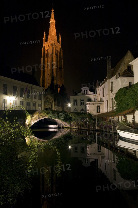 Church and buildings along canal at night