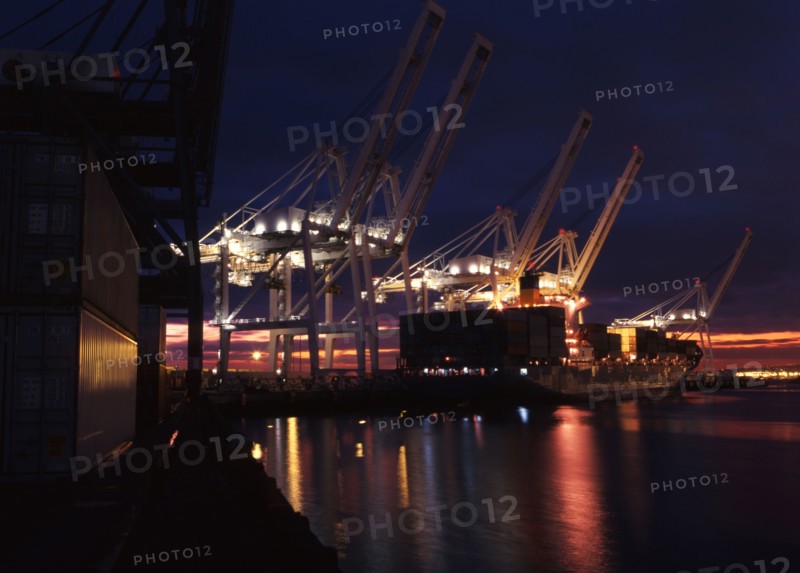 Illuminated cranes over commercial dock at night